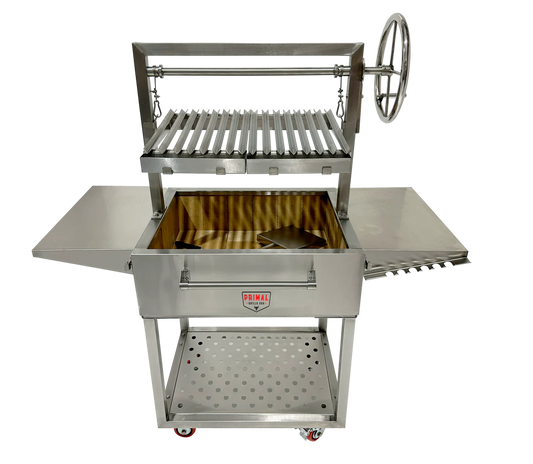 Primal Grills Live Fire Model 32 Inch fully stainless steel grill with side tables and rotisserie feature for outdoor cooking.