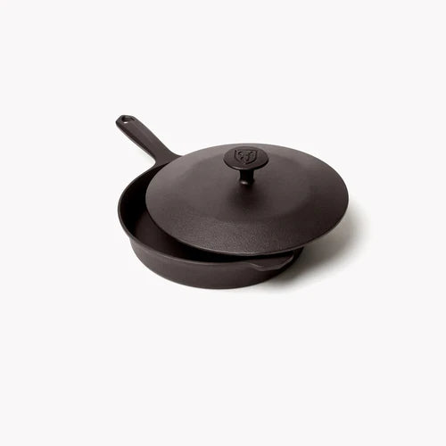 Field Company No. 6 Cast Iron Skillet Lid on top of the skillet, ideal for grilling and barbecue cooking.