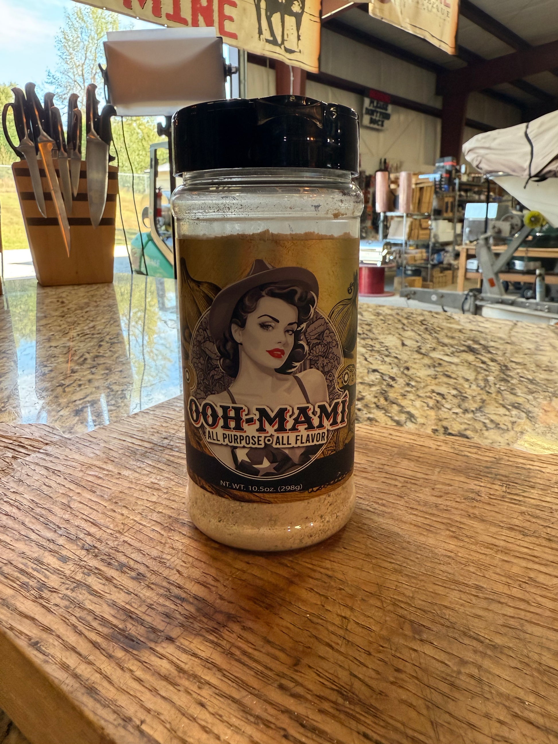 Ooh-Mami All Purpose Seasoning 10.5oz showcased on a wooden counter, perfect for grills, smokers, and BBQ enthusiasts.