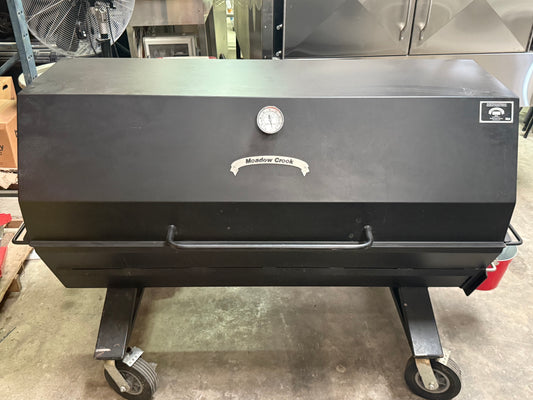 Meadow Creek PR60 W/ 8" Casters, Charcoal Pull Out, Charcoal Grilling Pan, Vinyl Cover, 2nd Tier Grate in a commercial kitchen.