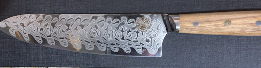 Spaceman Interstellar Chef Knife- Olive Wood Handle with 67-layer Damascus finish, ideal for precision in grilling and cooking.