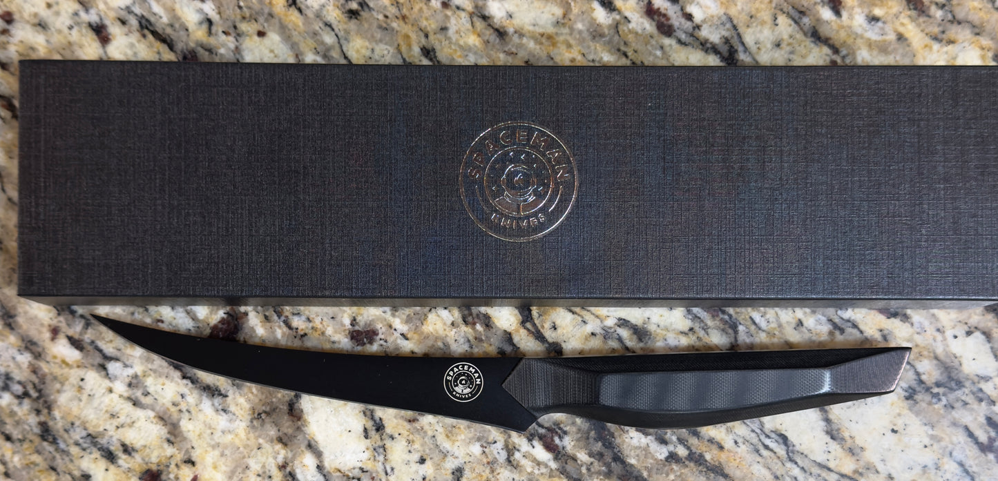 Spaceman Dark Matter Boning Knife displayed on a granite countertop with a sleek packaging.