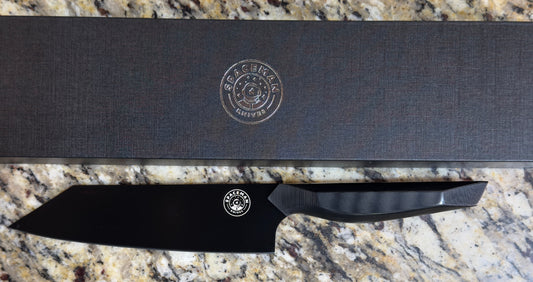 Spaceman Dark Matter Bunka Knife with sleek black finish and packaging on granite surface