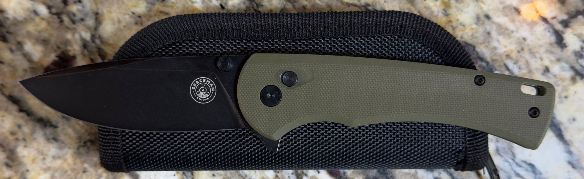 Spaceman SAO EDC Green Knife displayed on a textured surface with a sleek design and durable handle.