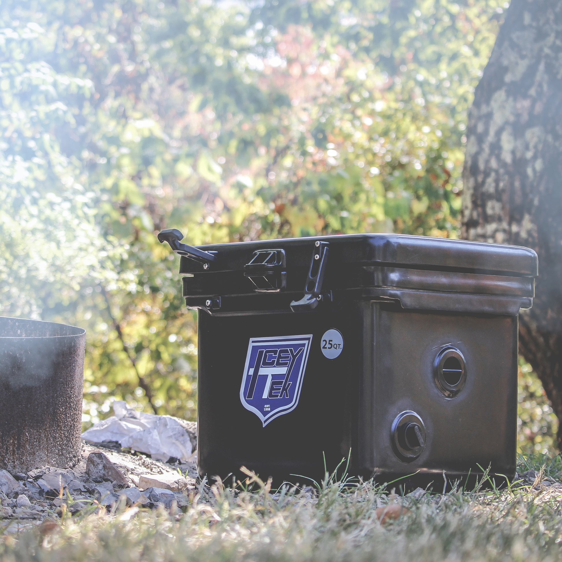 ICEY-TEK 25 Quart Cooler ( FREE SHIPPING ) placed next to a campfire in an outdoor setting.