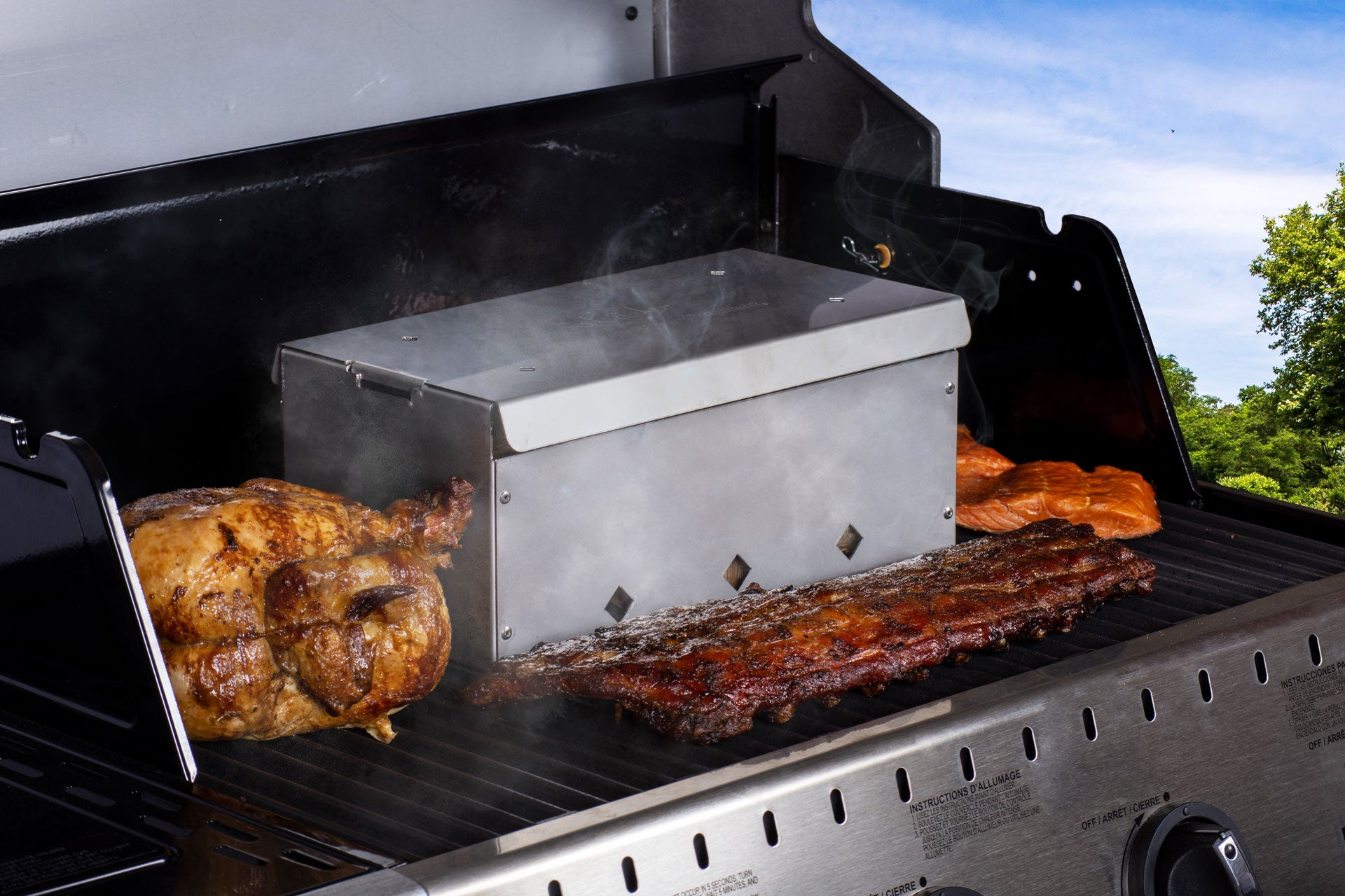 6x12 Smoker Box on grill with smoked meats, ideal for grills smokers and cookers, enhancing BBQ flavor and experience.