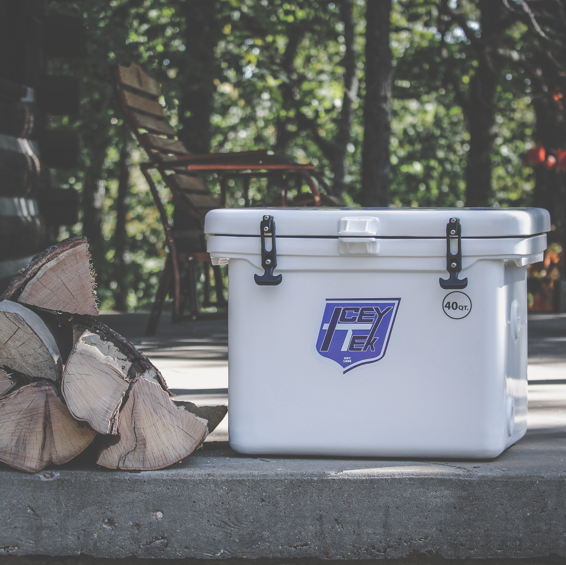 ICEY-TEK 40 Quart Cooler (FREE SHIPPING) placed beside firewood in a natural outdoor setting.