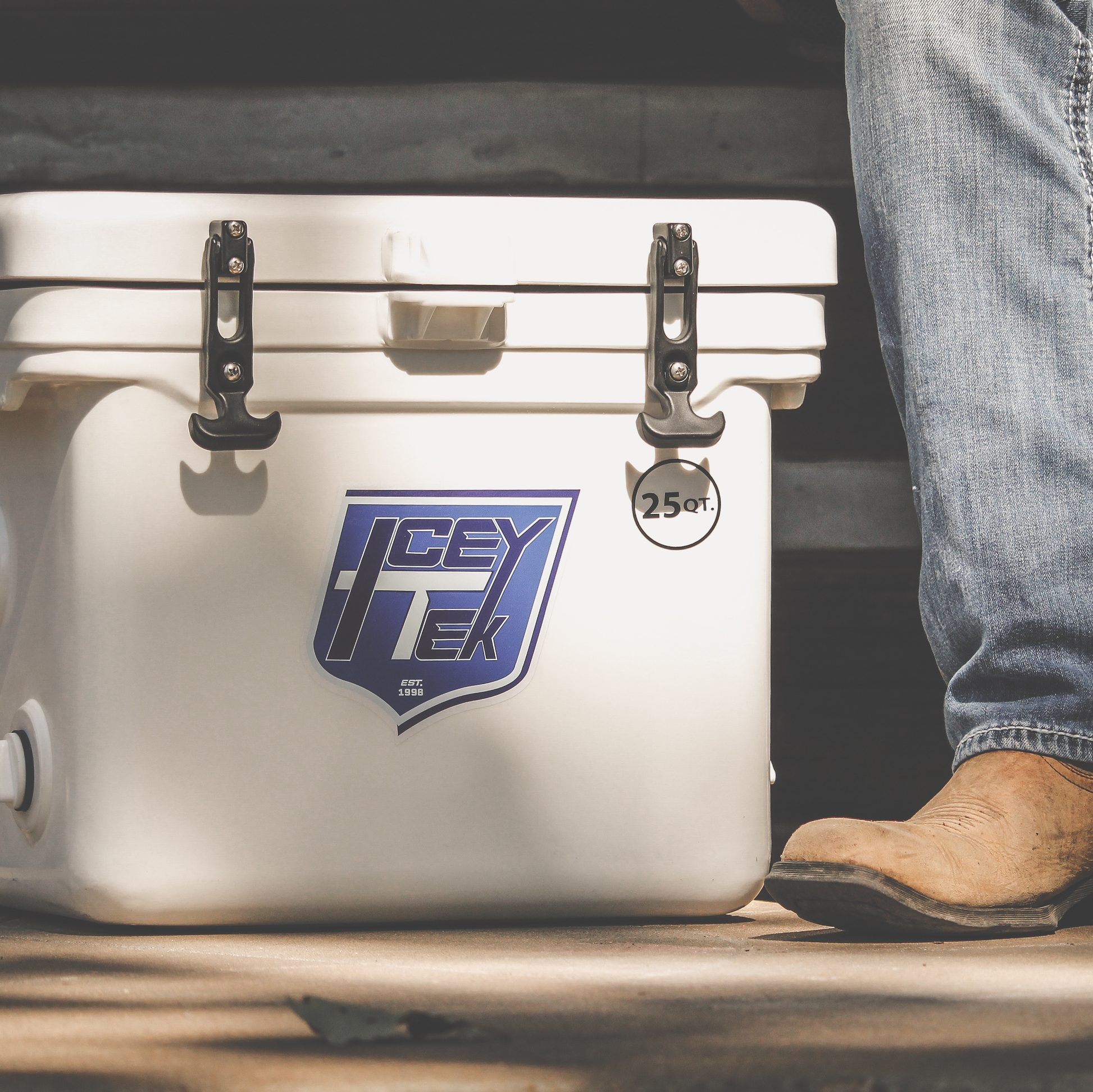 ICEY-TEK 25 Quart Cooler ( FREE SHIPPING ) placed outdoors near a person, showcasing its rugged design and portability.