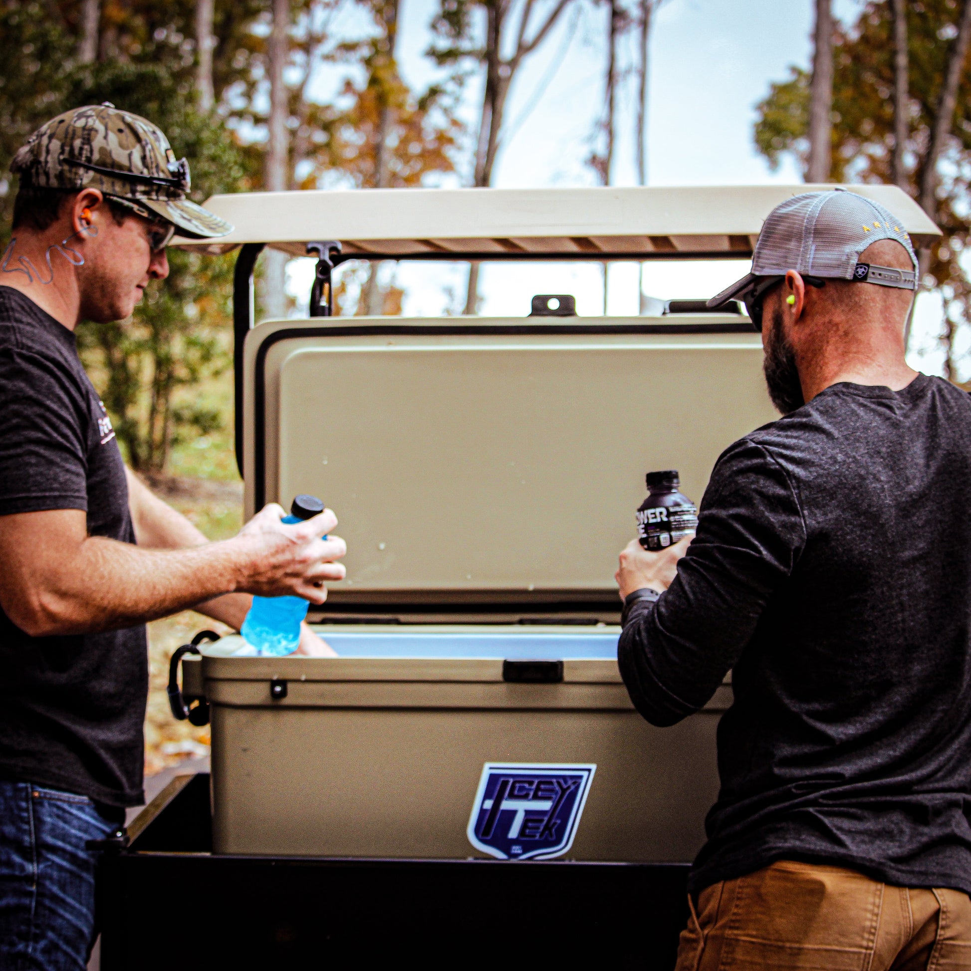Two men using the ICEY-TEK 95 Quart Cooler (FREE SHIPPING) outdoors for drinks while enjoying nature.