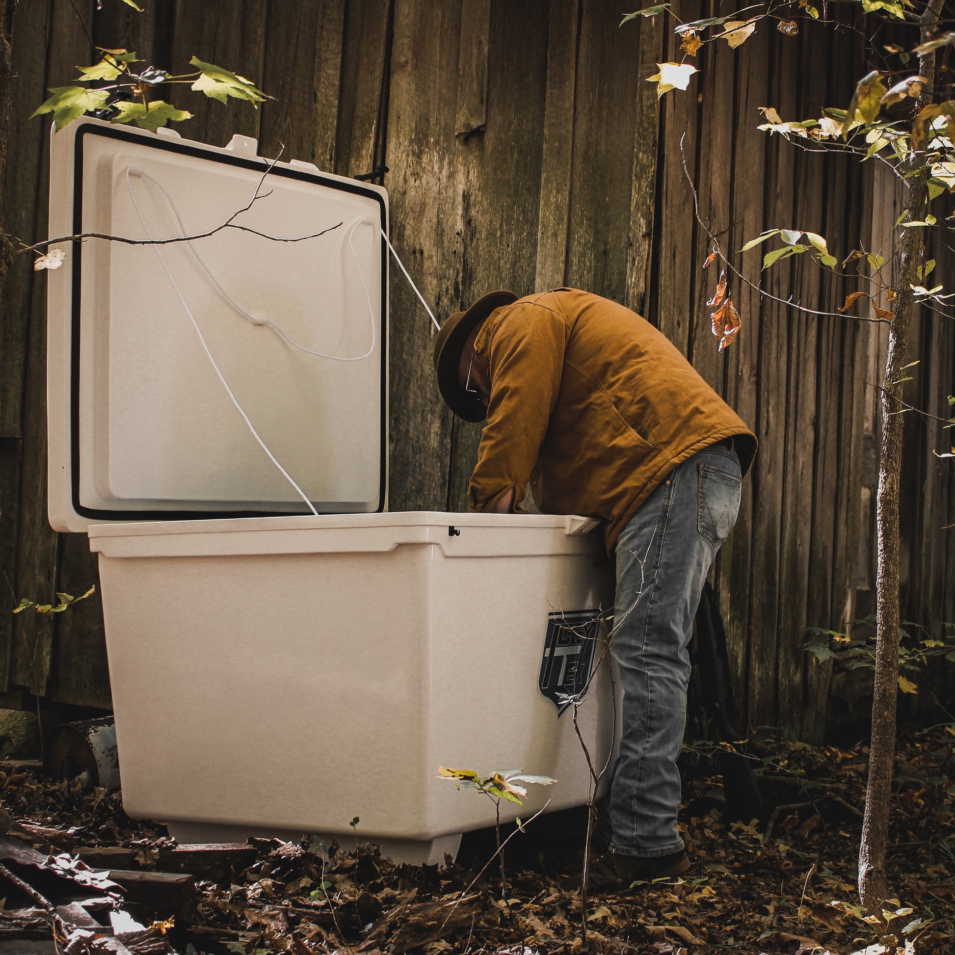 Person using the ICEY-TEK 600 Quart Cooler (FREE SHIPPING) outdoors, highlighting its rugged design for heavy-duty use.