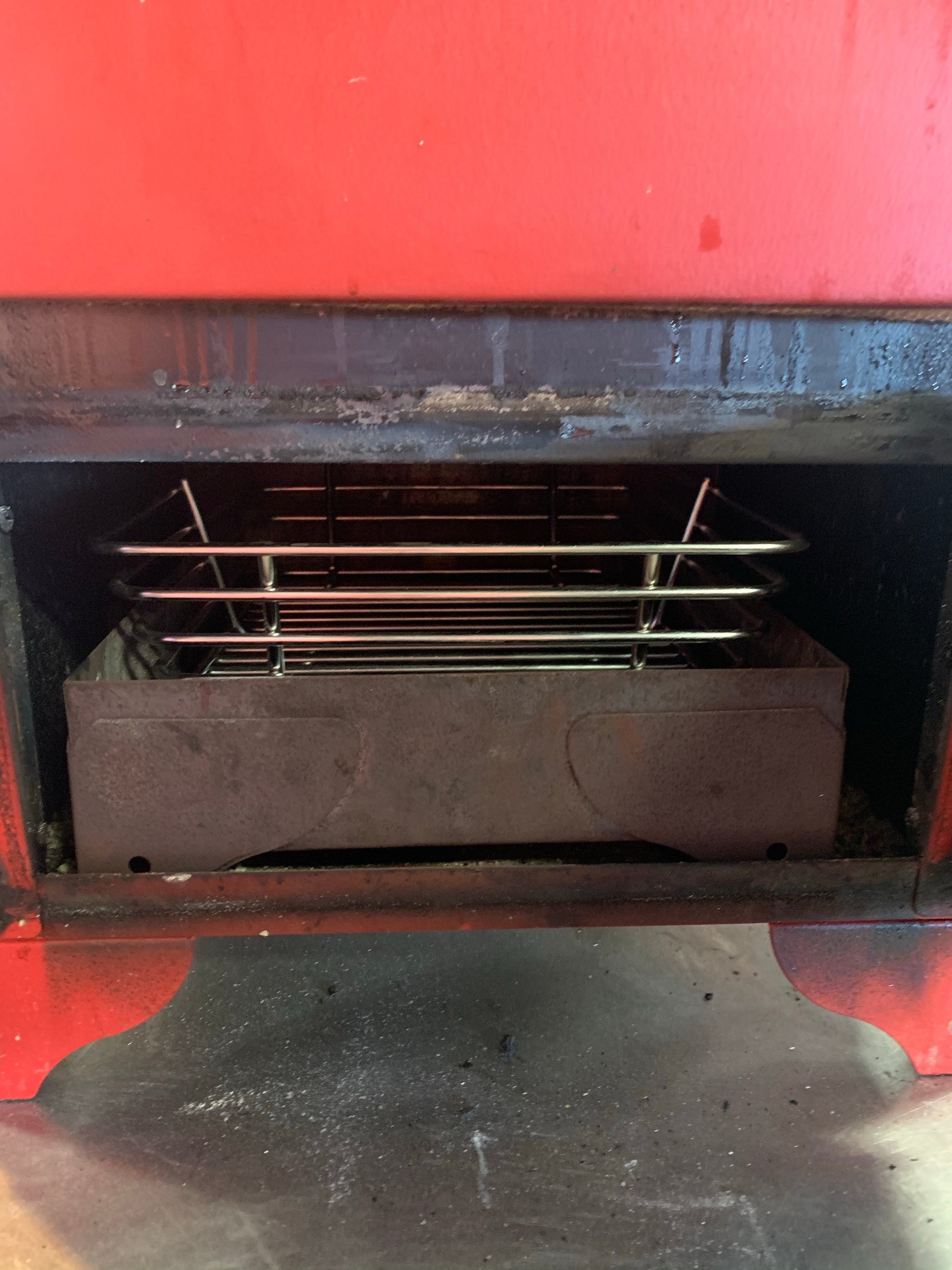 Kick Ash Basket for Red Box Smoker 12”x11”x5” deep inside a smoker, enhancing airflow for optimal grilling.