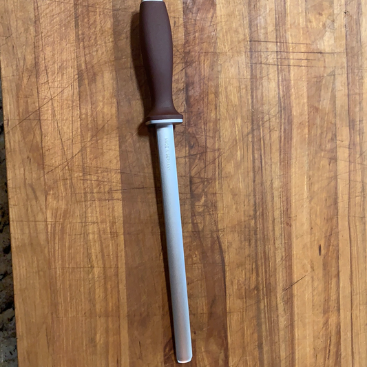 Gunter Wilhelm 10” German Oval Diamond steel sharpener on wooden cutting board, essential for grills, smokers, and cookers.