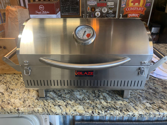Blaze PRO Portable Grill LP Gas displayed on a countertop, showcasing its stainless steel design and temperature gauge.