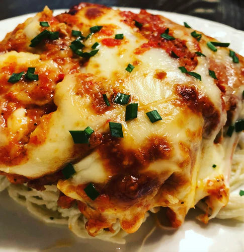 Delicious Quick 'N' Easy Chicken Parmesan topped with herbs and marinara sauce on a plate.