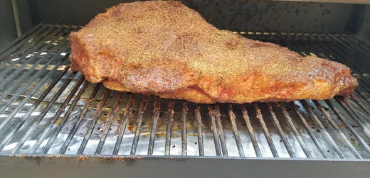Pork Shoulder seasoned and smoking on a grill, perfect for BBQ enthusiasts and outdoor grilling.
