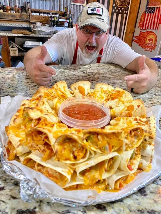 Delicious cheesy baked nachos with salsa, showcased by enthusiastic chef at a BBQ restaurant.
