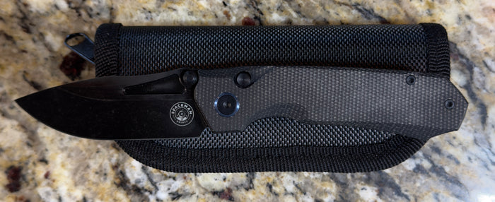 Spaceman N1 EDC Pocket Knife resting on a textured surface, ideal for grilling and outdoor cooking tools.