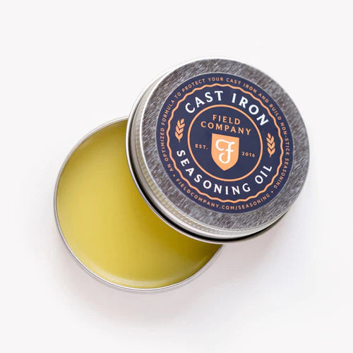 Field Company Cast Iron Seasoning Oil in a tin, ideal for grills smokers and cookers to enhance non-stick properties.