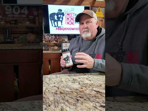 Sweet Rub O' Mine Apple Chipotle BBQ Rub showcased by a pitmaster with BBQ accessories in the background.