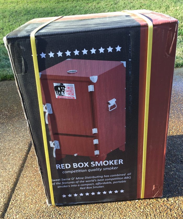 Red Box Smoker (firebox insert not included) packaged for delivery, featuring competition quality design and branding.
