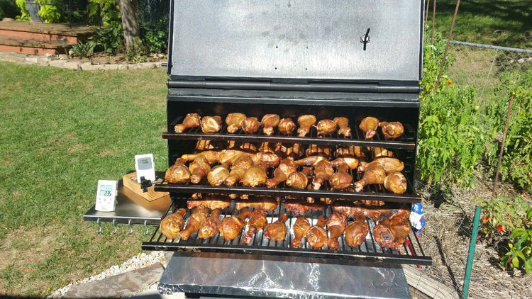 American Barbecue Systems All Star Smoker loaded with grilled chicken legs, showcasing grilling and smoking features.
